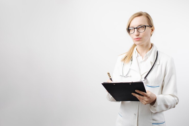 Doctora escribiendo en el portapapeles y mirando a un lado