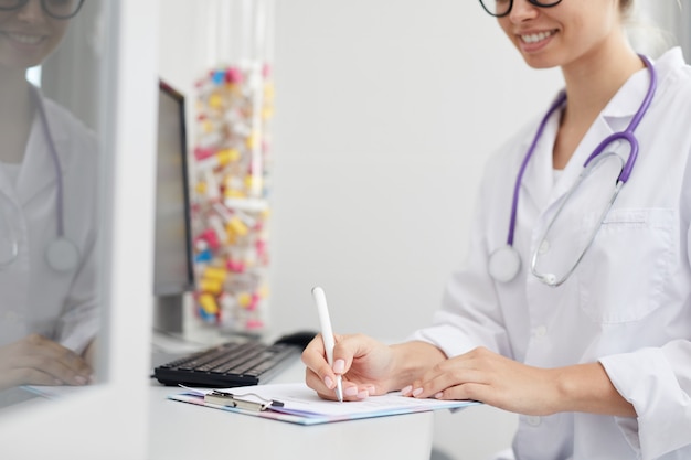 Doctora escribiendo en portapapeles