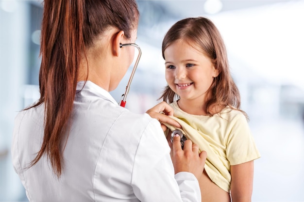 Doctora escuchando el corazón roto de una niña preescolar.