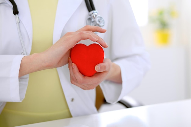 Doctora con estetoscopio con corazón. Pareja de pacientes sentada en el fondo