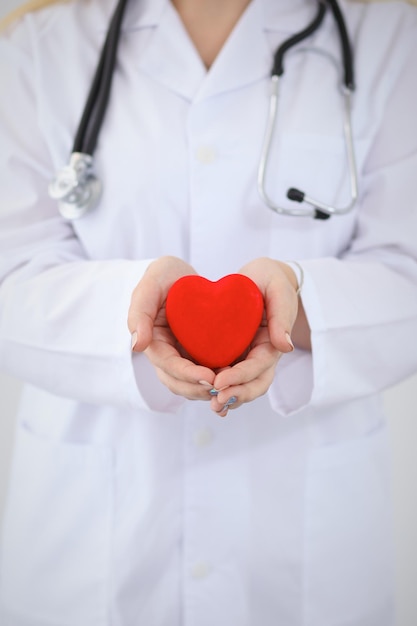 Doctora con estetoscopio con corazón. Pareja de pacientes sentada en el fondo