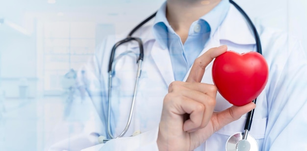 Foto doctora con estetoscopio con corazón rojo en la oficina del hospital atención médica y servicios del personal médico internacional