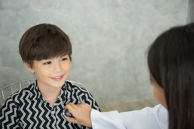 Doctora con un estetoscopio examinando a un niño en el hospital.