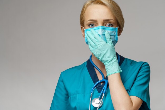 Doctora con estetoscopio con máscara protectora y guantes de látex