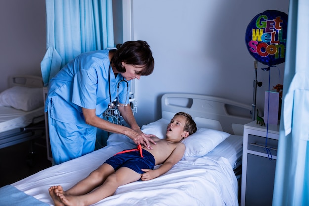 Doctora examinando el abdomen del paciente