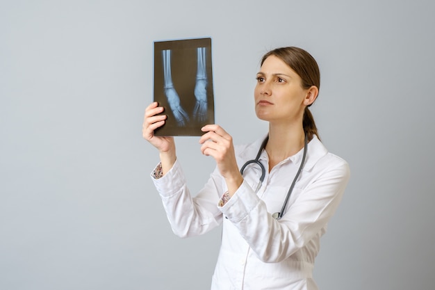 Doctora examinando imágenes de rayos x de las piernas del bebé recién nacido