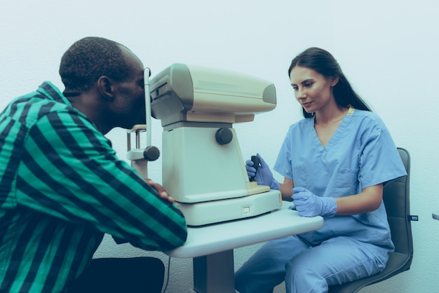 Doctora está examinando los ojos del paciente