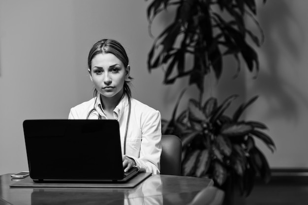 Doctora exitosa trabajando en una computadora portátil