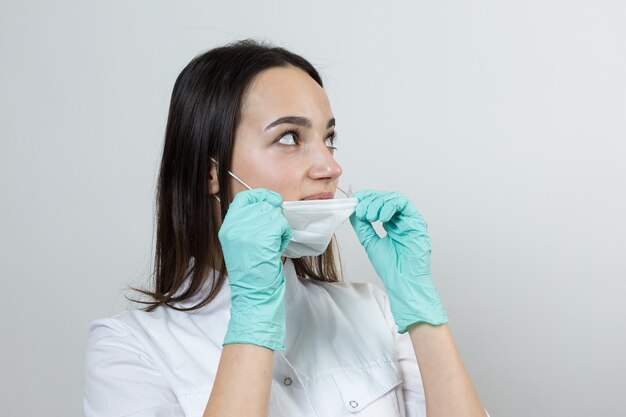 Una doctora con guantes de látex y una bata blanca se está preparando para los procedimientos.