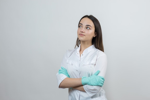 Foto una doctora con guantes de látex y una bata blanca se está preparando para los procedimientos.