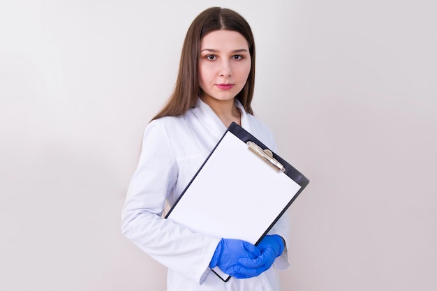 Doctora con guantes de protección y sosteniendo notas.