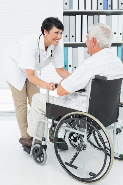 Doctora hablando con paciente senior en silla de ruedas