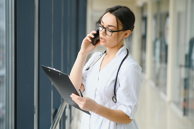 Doctora hablando por teléfono móvil en la clínica