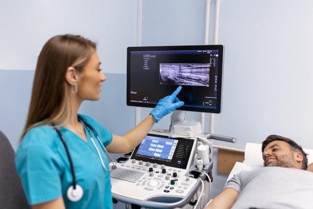 Doctora haciendo un examen de ultrasonido de las venas del brazo del paciente en su oficina Joven pasando una ecografía en la clínica Trabajo médico Investigación médica