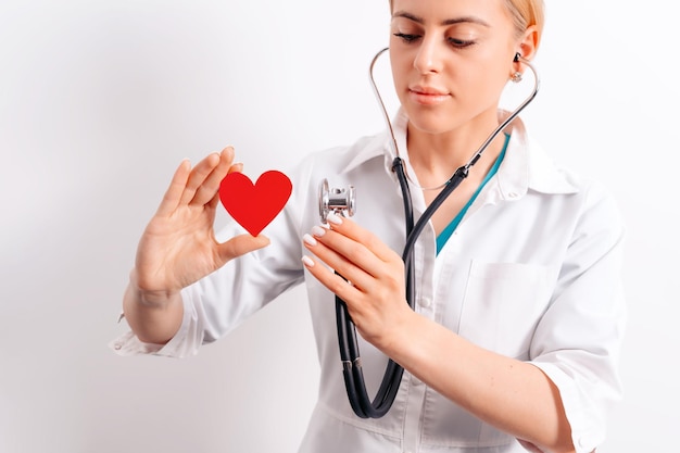 Doctora joven y hermosa sosteniendo un corazón de papel rojo en sus manos Trasplantología y salud