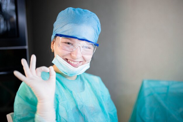 Doctora joven positiva en uniforme y máscara de gafas