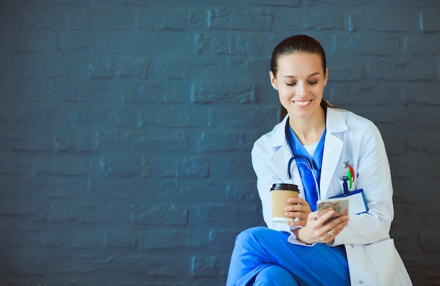 Doctora joven sentada con su teléfono