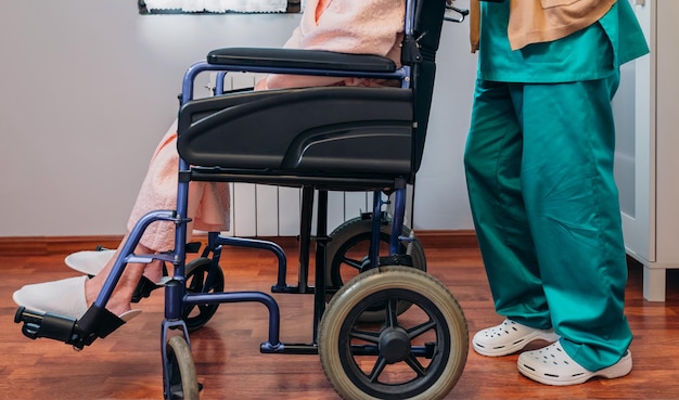 Foto doctora llevando paciente anciana en silla de ruedas