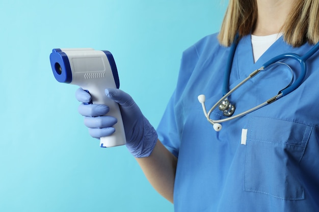Doctora mantenga pistola termómetro en azul