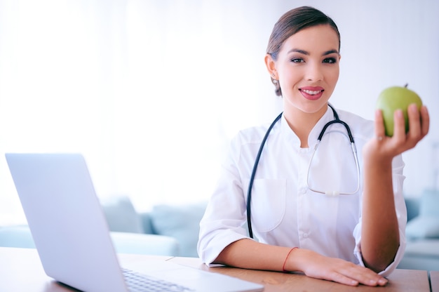 Doctora con manzana verde en el hospital. Concepto de nutrición sanitaria médica