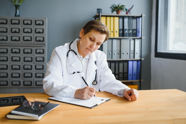 Doctora de mediana edad escribiendo receta