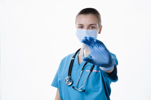 Doctora con medicina en mano sobre un fondo blanco.