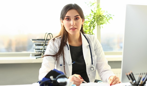 Doctora de medicina con la mano sosteniendo una pluma de plata