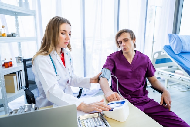 Doctora midiendo la presión en el brazo de un paciente