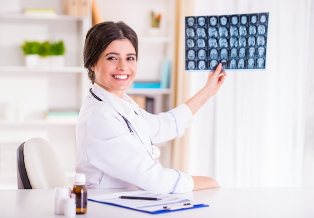 La doctora mira una radiografía de un paciente.