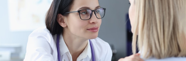 Doctora mirando al paciente y sosteniendo su hombro concepto de apoyo psicológico