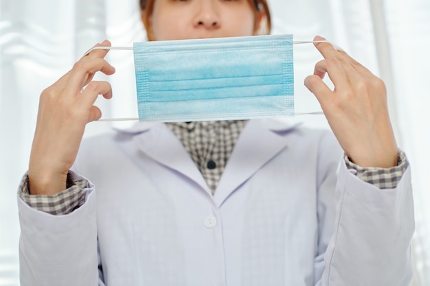 Doctora mostrando cómo ponerse la mascarilla médica