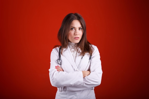 Foto doctora mostrando diferentes emociones sobre fondo rojo.