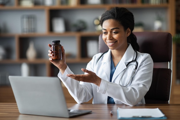 Doctora negra que trabaja en línea con video chat con el paciente