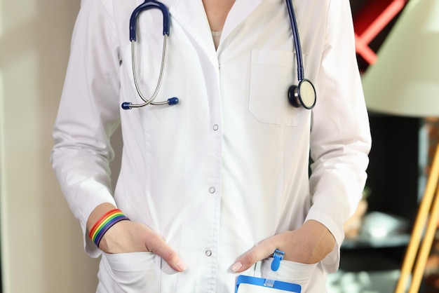 Doctora o enfermera con brazalete lgbt en la mano cerca de la salud transgénero y gay