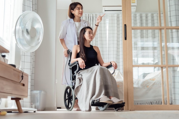 Una doctora o enfermera está cuidando a un paciente en silla de ruedas