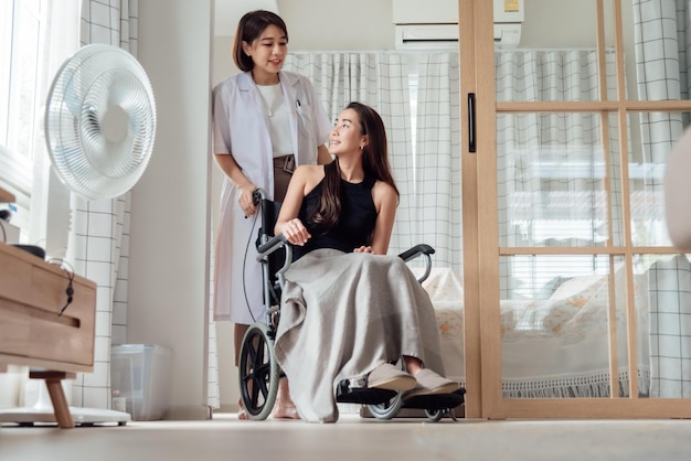 Una doctora o enfermera está cuidando a un paciente en silla de ruedas