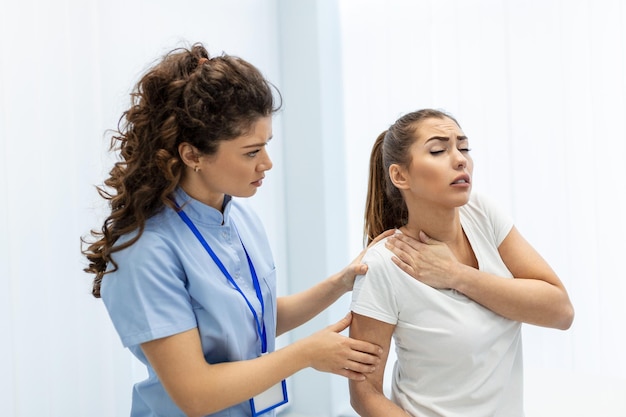 Doctora osteópata en uniforme médico arreglando las articulaciones de los hombros y la espalda de las pacientes en la clínica de terapia manual durante la visita Osteópata profesional durante el trabajo con el concepto de paciente