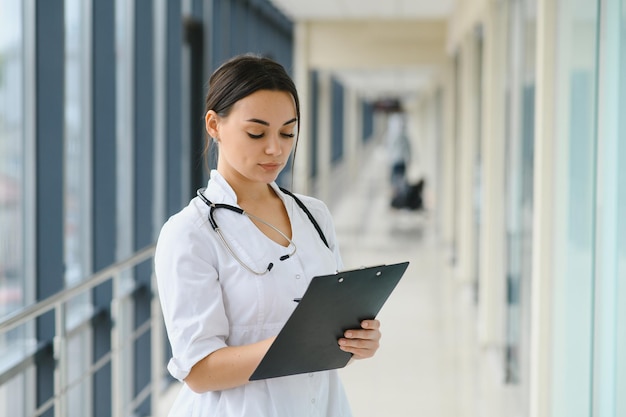 Doctora de pie con carpeta en el hospital