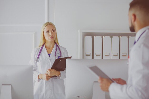 Doctora de pie con carpeta en el hospital