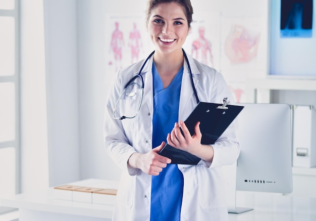 Doctora de pie con carpeta en el hospital