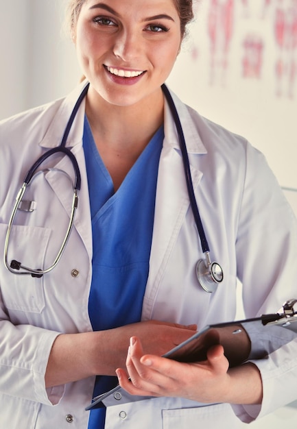 Doctora de pie con carpeta en el hospital