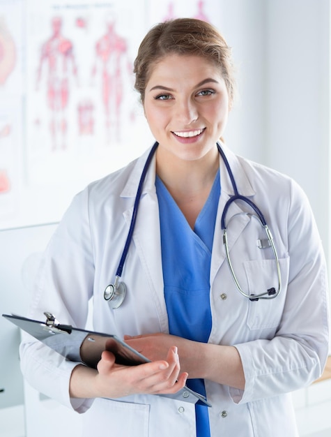 Doctora de pie con carpeta en el hospital