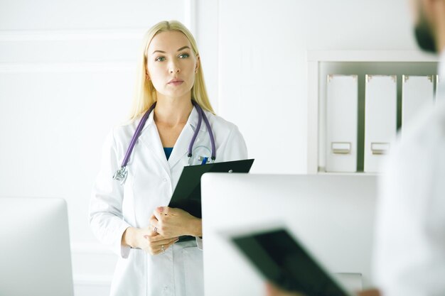 Doctora de pie con carpeta en el hospital