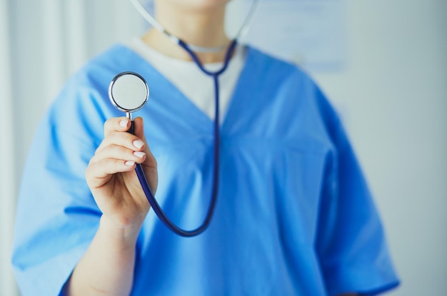 Doctora de pie con estetoscopio en el hospital