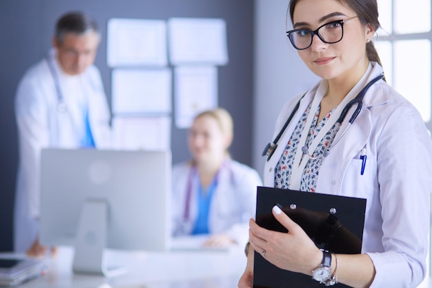 Foto doctora de pie con estetoscopio en el hospital