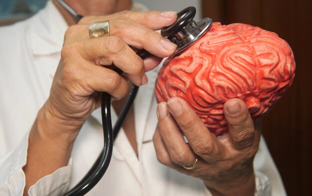 Foto una doctora pone el estetoscopio en el cerebro