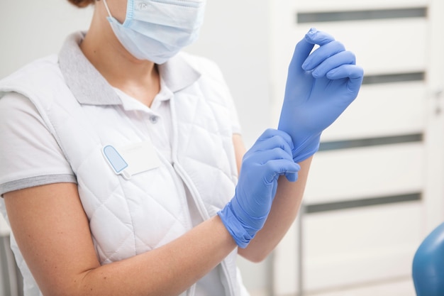Doctora poniéndose guantes de goma, trabajando en el hospital