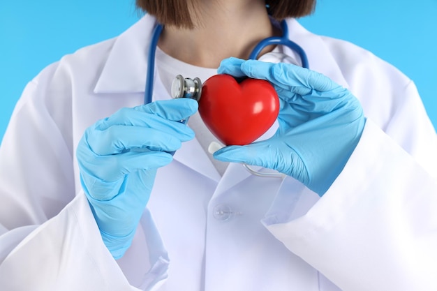 Doctora en prácticas con corazón sobre fondo azul.