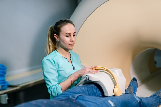 Doctora preparándose para proporcionar rayos x en la moderna sala médica con tomografía computarizada.