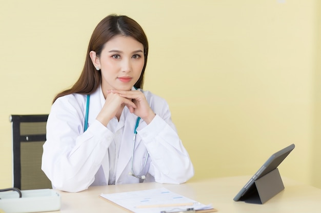 Doctora profesional asiática está esperando ser examinada en la sala de examen.